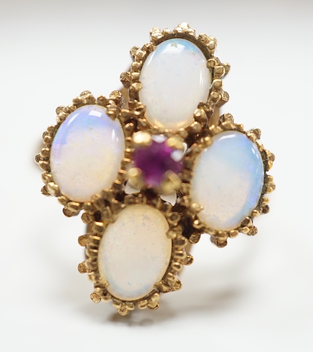 A 1970's 9ct gold, four stone white opal and single stone ruby cluster set dress ring, size O, gross weight 5.2 grams.
